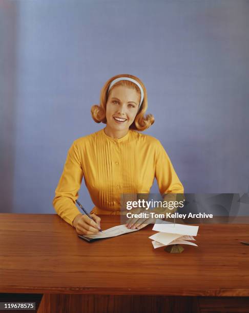 mujer joven rellenar bank antideslizante, sonriendo, vertical - bank deposit slip fotografías e imágenes de stock