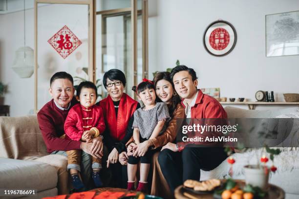 drei generationen fröhlicher asiatischer familie umarmen und feiern gemeinsam das chinesische neujahr - chinese man stock-fotos und bilder