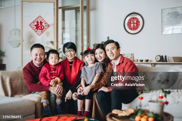 三代歡樂的亞洲家庭共同擁抱和慶祝中國新年 - 中國新年 個照片及圖片檔