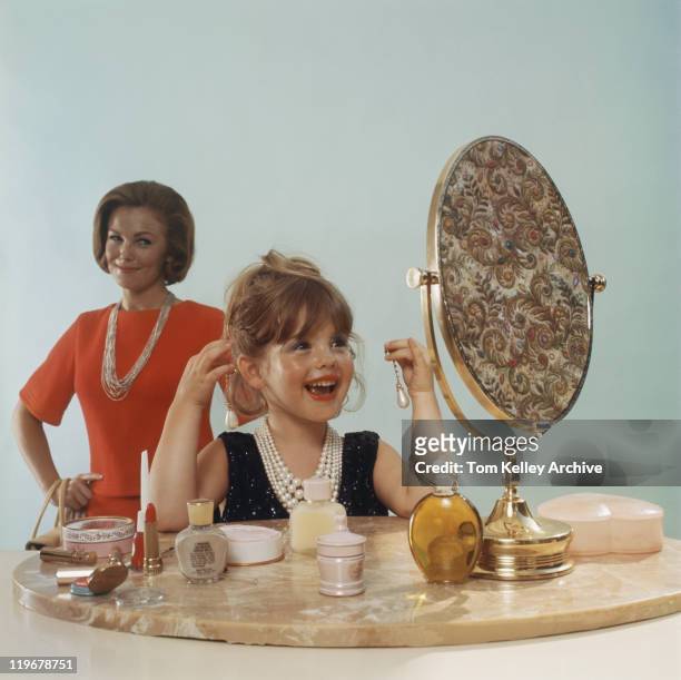 daughter looking in mirror at dressing table and mother watching her, smiling - vintage jewelry stock pictures, royalty-free photos & images