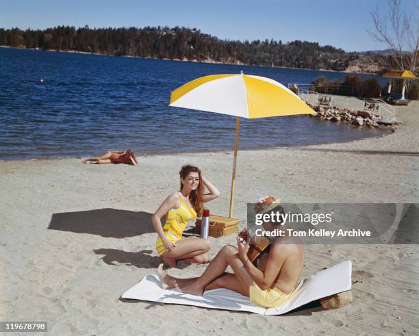 man playing guitar while woman dancing at beach - 1968 stock pictures, royalty-free photos & images