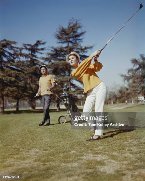 young women playing golf while man standing in background - sports archive stockfoto's en -beelden