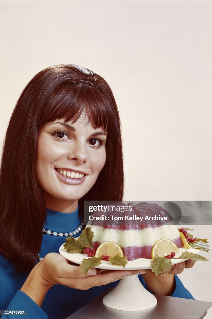 Woman holding mousse against white background, close-up, portrait