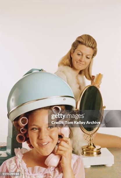 laminados cabelo de menina adolescente com cabelo steamer, mãe no backgr - 1970 imagens e fotografias de stock