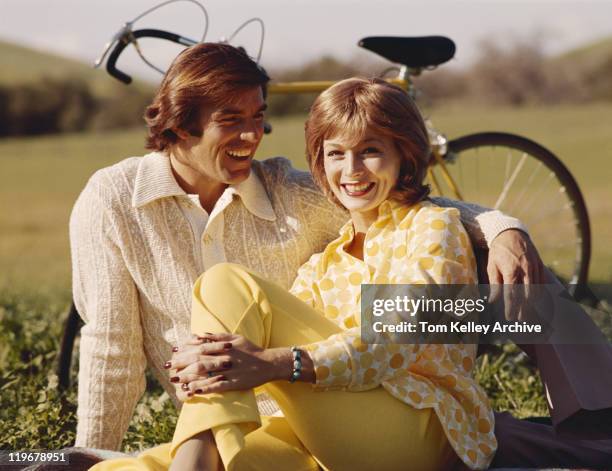 casal sentado na grama, bicicleta em fundo - 1970 imagens e fotografias de stock