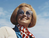 Young woman wearing sunglasses, smiling, close-up