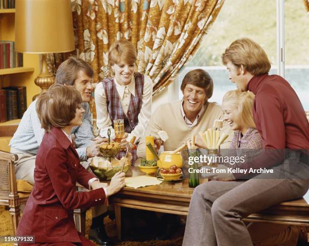 amis ayant un repas dans la salle de séjour - 1972 photos et images de collection