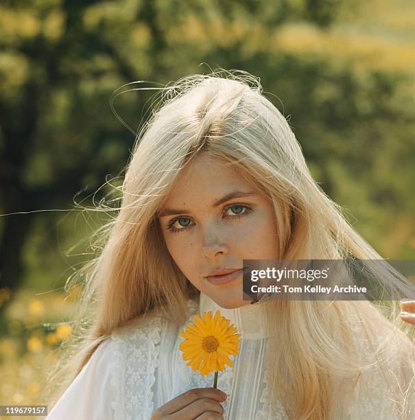 young woman holding flower, portrait, close-up - women 1970s stock pictures, royalty-free photos & images