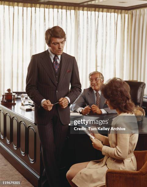 three businesspeople in office, young woman making notes - archival business stock pictures, royalty-free photos & images