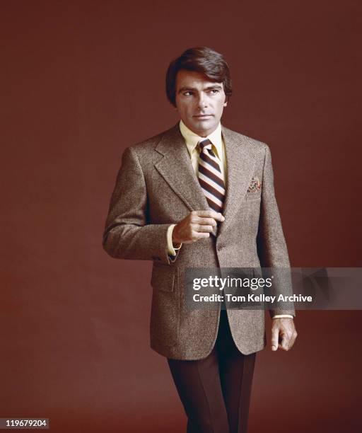 man in full suit standing against red background - 1973 stock pictures, royalty-free photos & images