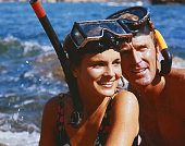 Couple wearing snorkel, smiling, close-up