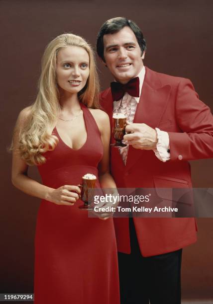 couple in red clothes with coffee cup against brown background - archival man stock pictures, royalty-free photos & images