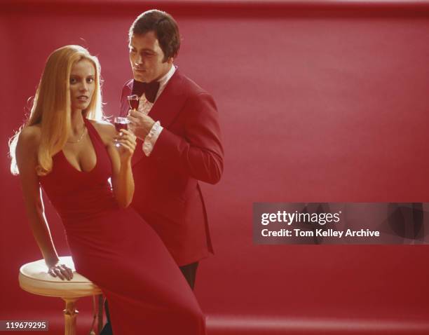 couple in red clothes with red wine against red background - archival alcohol stock pictures, royalty-free photos & images