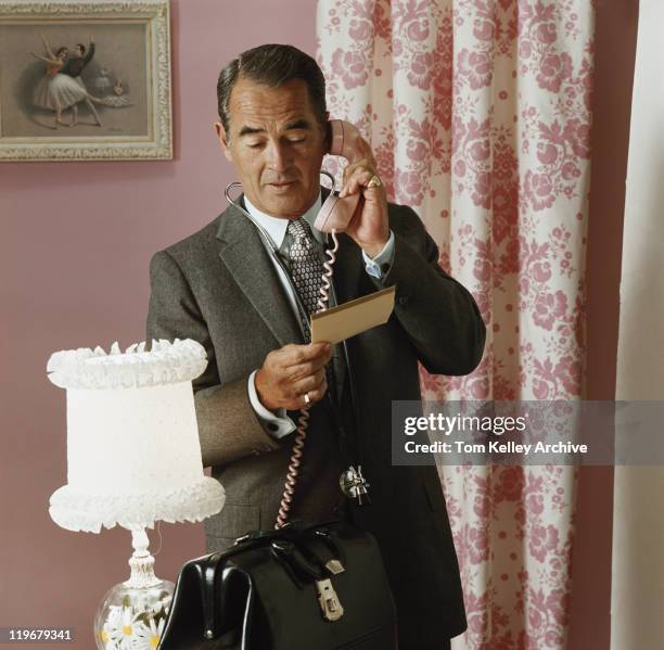 mature doctor talking on phone - archival doctor stock pictures, royalty-free photos & images