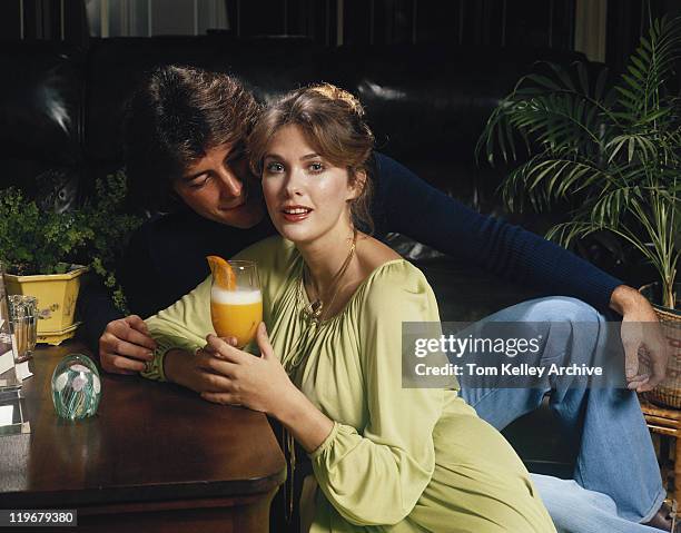 casal jovem sentado à mesa, mulher a segurar vidro - 1978 imagens e fotografias de stock