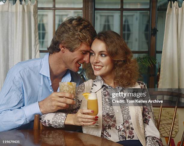 couple holding glasses of cocktail, smiling - archival alcohol stock pictures, royalty-free photos & images