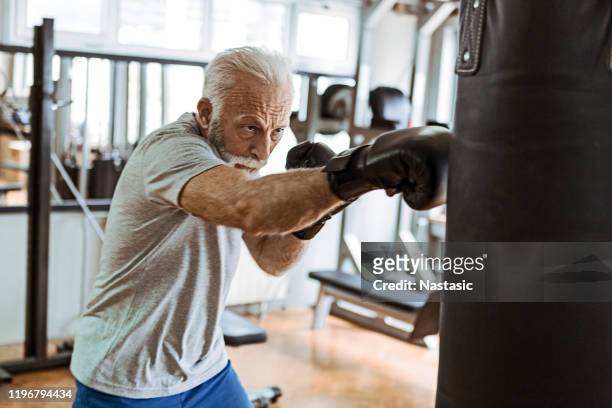 senior in gym training boksen - slaan met vuist stockfoto's en -beelden