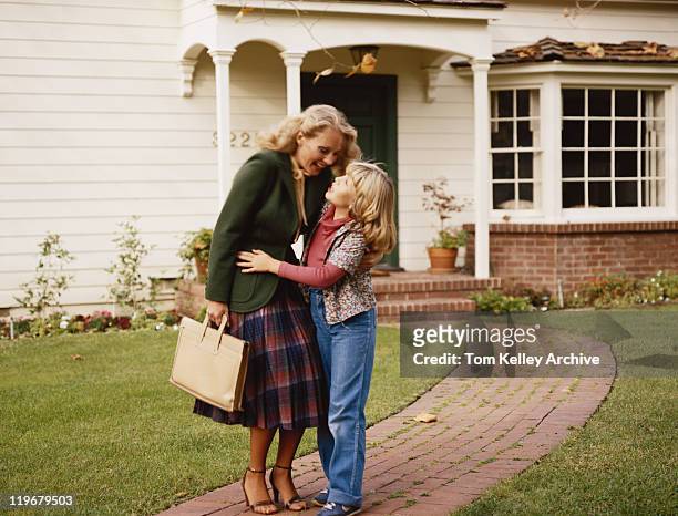 madre abbracciare sua figlia fuori casa sul sentiero di giardino - anno 1980 foto e immagini stock