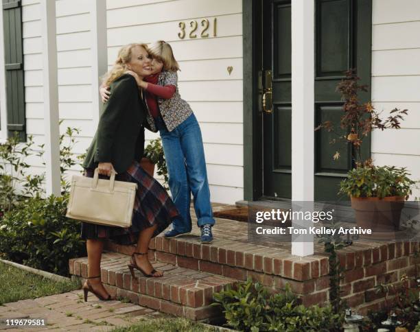 daughter kissing mother on doorstep - vintage handbag stock pictures, royalty-free photos & images