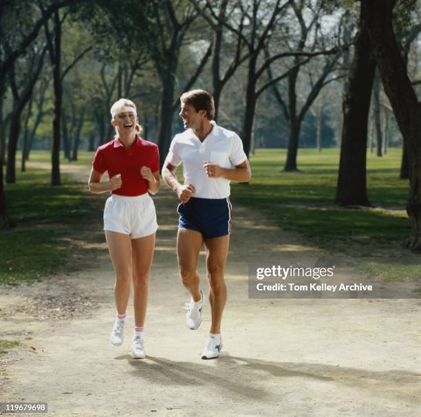 paar joggen im park, lächeln - 80's stock-fotos und bilder