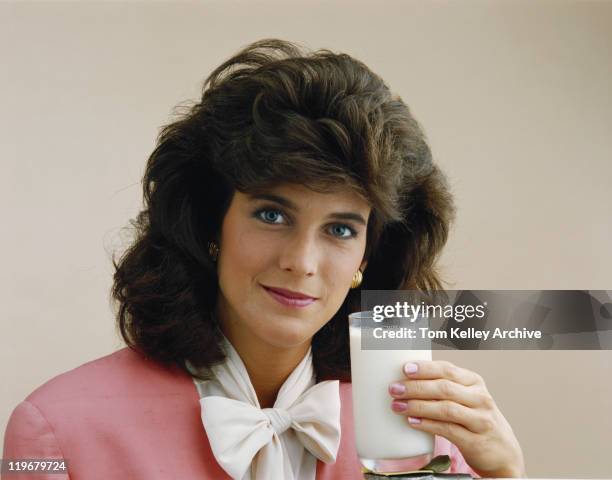 young woman holding glass of milk, smiling, portrait - achtziger jahre stock-fotos und bilder