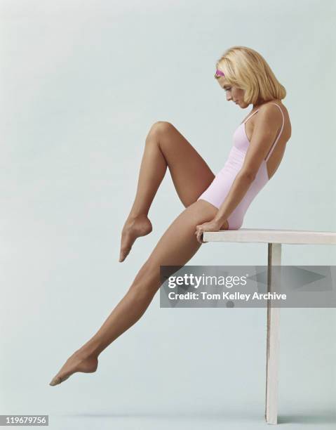 young woman stretching on balance beam - leotard stockfoto's en -beelden