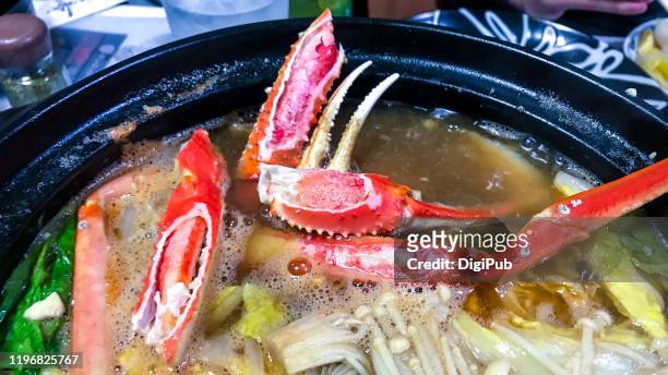 snow crab legs and claws in nabe hotpot - broth stock pictures, royalty-free photos & images