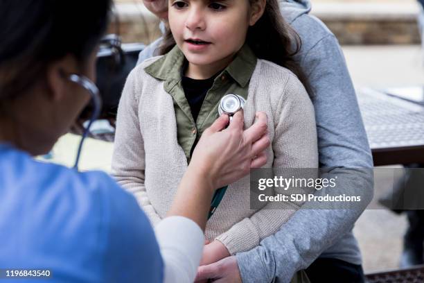 unrecognizable volunteer doctor checks young girl at free cllinic - worry free stock pictures, royalty-free photos & images