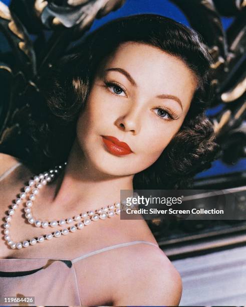 Headshot of Gene Tierney , US actress, wearing a white pearl necklace in a studio portrait, circa 1940.
