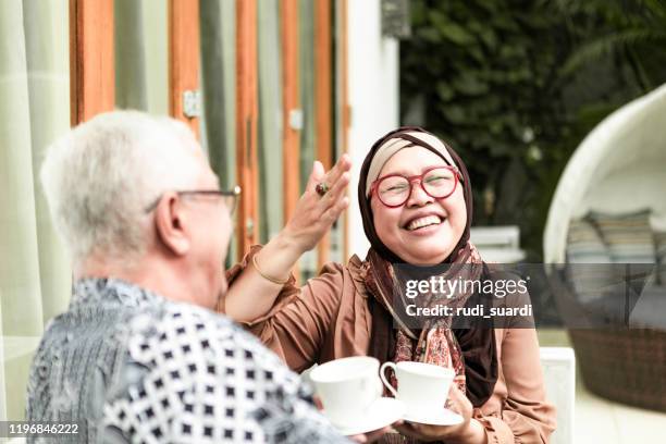 gepensioneerd stel met teatime relax concept - batik indonesia stockfoto's en -beelden