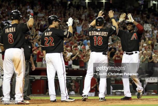 Justin Upton of the Arizona Diamondbacks high-fives teammates Gerardo Parra, Xavier Nady and Willie Bloomquist after Upton hit a grand slam home run...