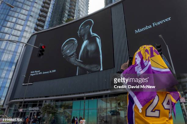 Fan photographs a mural memorializing former NBA star Kobe Bryant, who was killed in a helicopter crash in Calabasas, California, near the Staples...