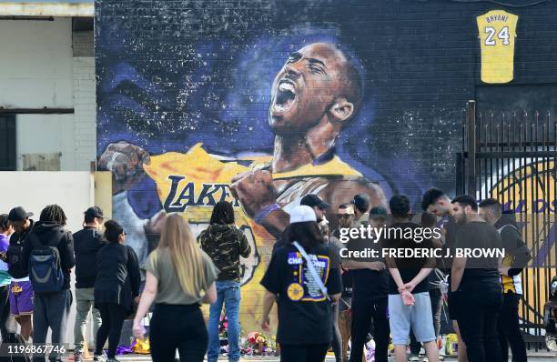 Fans gather to mourn the death of NBA legend Kobe Bryant at a mural near Staples Center in Los Angeles, California on January 27 a day after nine...
