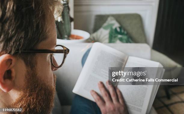 man reading a book - filosofía fotografías e imágenes de stock