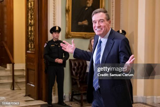 Senator Mark Warner smiles and raises his hands in response to shouted questions from reporters as he heads back to the Senate floor following a...