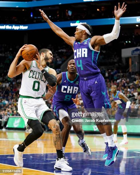 Jayson Tatum of the Boston Celtics is defended by Devonte' Graham of the Charlotte Hornets during the third quarter during their game at Spectrum...