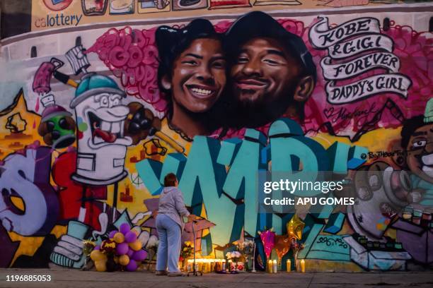 Woman looks at a mural by the artists Muck Rock and Mr79lts showing Kobe Bryant and his daughter Gianna Bryant, who were killed with seven others in...