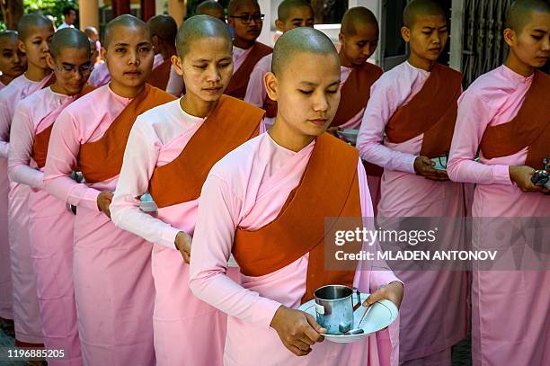 This photograph taken on January 15, 2020 shows Buddhist novice nuns standing in line for breakfast at a monastic school in Sagaing outside Mandalay....