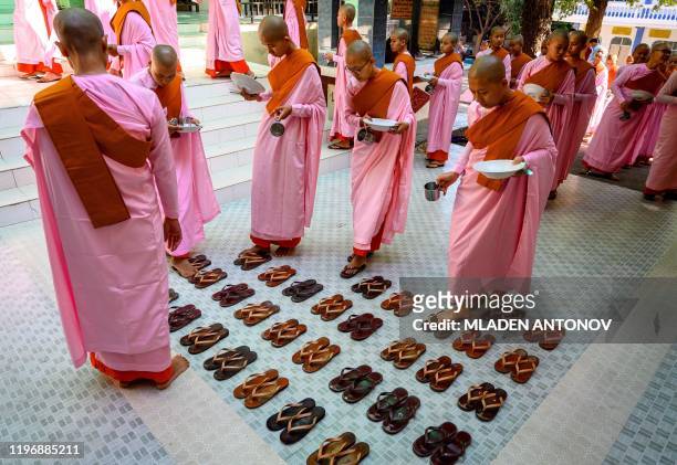 This photograph taken on January 15, 2020 shows Buddhist novice nuns arranging their sandals before breakfast at a monastic school in Sagaing outside...