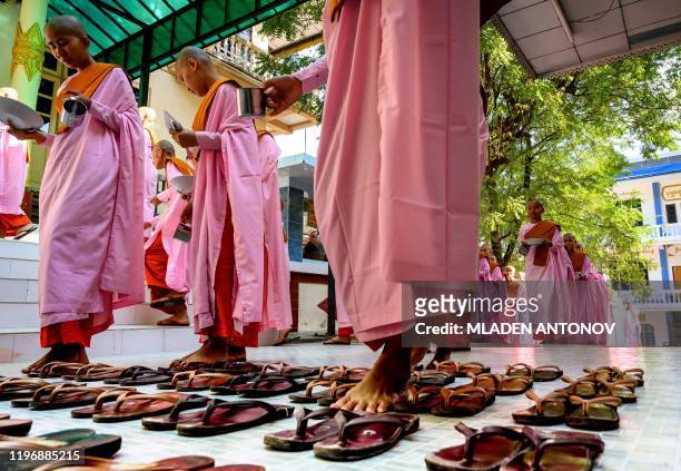 This photograph taken on January 15, 2020 shows Buddhist novice nuns arranging their sandals before breakfast at a monastic school in Sagaing outside...