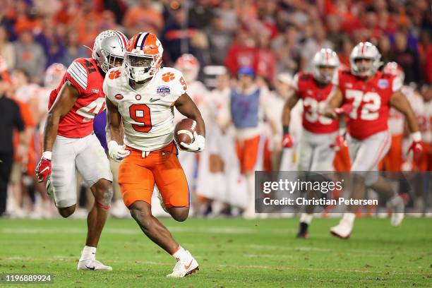 Running back Travis Etienne of the Clemson Tigers rushes the football against the Ohio State Buckeyes during the PlayStation Fiesta Bowl at State...