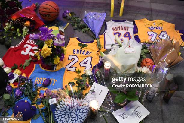 Jerseys, flowers and candles are placed at a makeshift memorial as fans mourn the death of NBA legend Kobe Bryant, who was killed along with his...