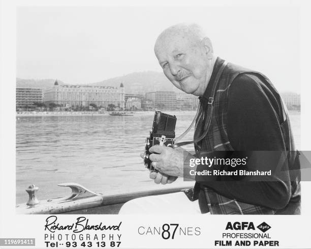 English film director Michael Powell taking pictures of the Promenade de la Croisette from a boat, during the Cannes Film Festival, France, May 1987....