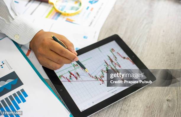 business documents on office table with smart phone and digital tablet and graph financial - assessment graph stock-fotos und bilder