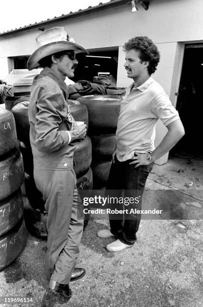 Richard Petty , driver of the STP Pontiac, talks with his son, Kyle Petty, in the garage at the Daytona International Speedway prior to the start of...