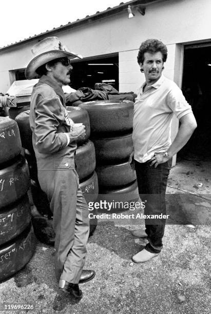 Richard Petty , driver of the STP Pontiac, talks with his son, Kyle Petty, in the garage at the Daytona International Speedway prior to the start of...