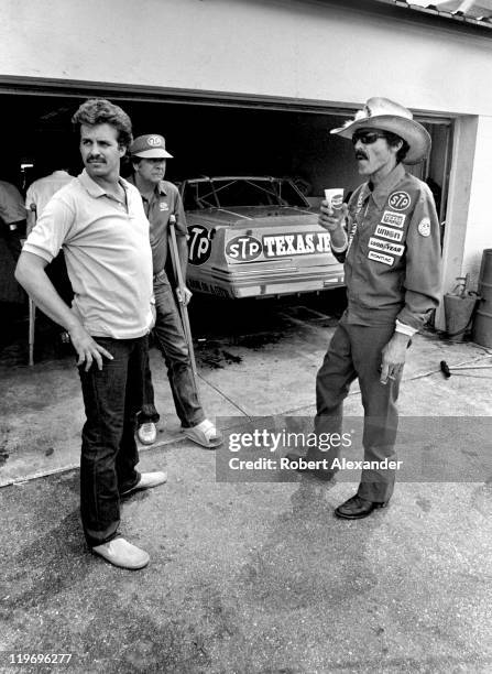 Richard Petty , driver of the STP Pontiac, talks with his son, Kyle Petty, in the garage at the Daytona International Speedway prior to the start of...