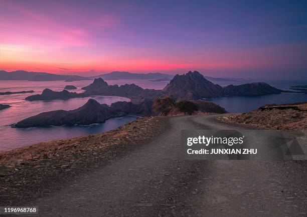 dirt road to the beautiful scenery of island padar of indonesia - komodo island stock-fotos und bilder