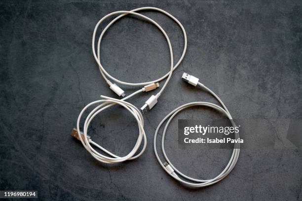 smart phone charger cables on black background - charging cable stock pictures, royalty-free photos & images