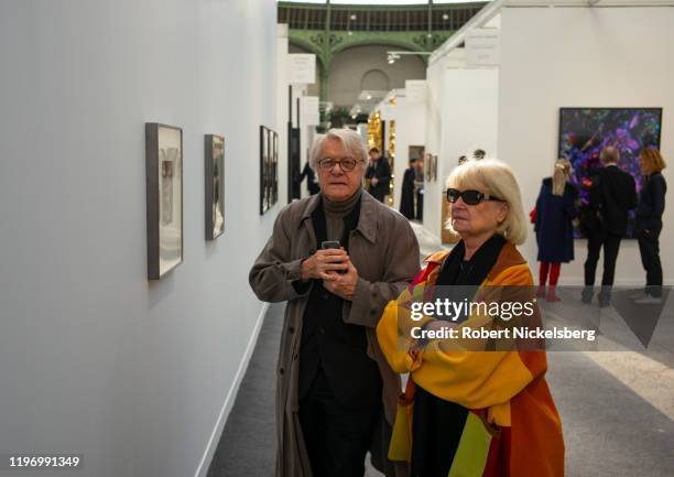 Couple attending the annual Paris Photo photography art fair walk down a hallway of photographs at the Grand Palais in Paris, France on November 6,...